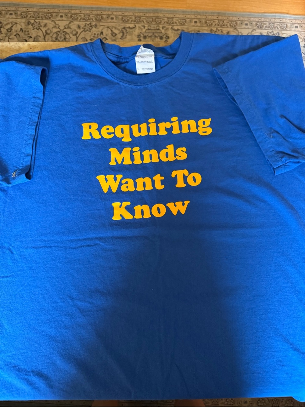 Blue Graphic Tee with Yellow Text - "Requiring Minds Want To Know"